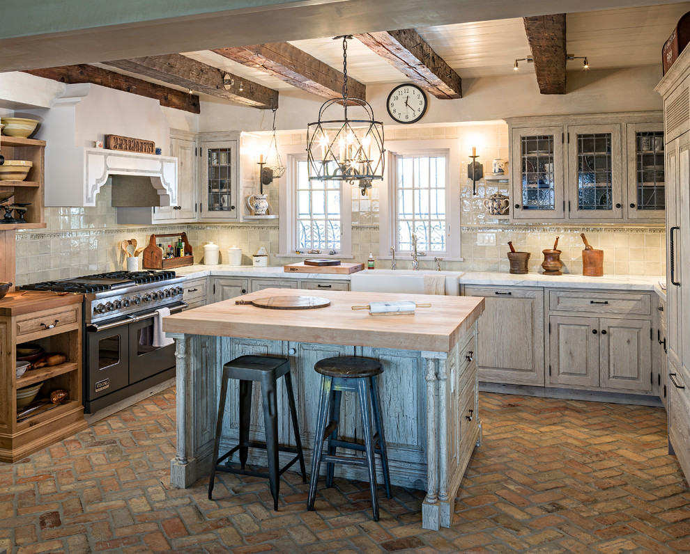 Inspiration for a mid-sized country u-shaped separate kitchen in Burlington with a farmhouse sink, raised-panel cabinets, distressed cabinets, marble benchtops, beige splashback, ceramic splashback, panelled appliances, brick floors and with island.