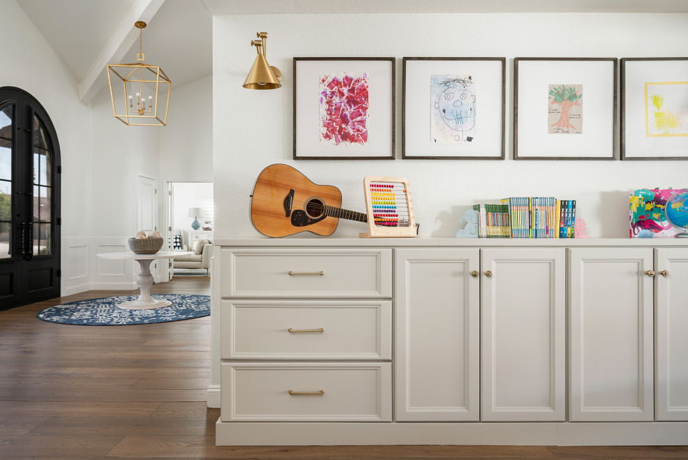 This is an example of a mid-sized transitional gender-neutral kids' playroom for kids 4-10 years old in Phoenix with white walls, light hardwood floors and brown floor.