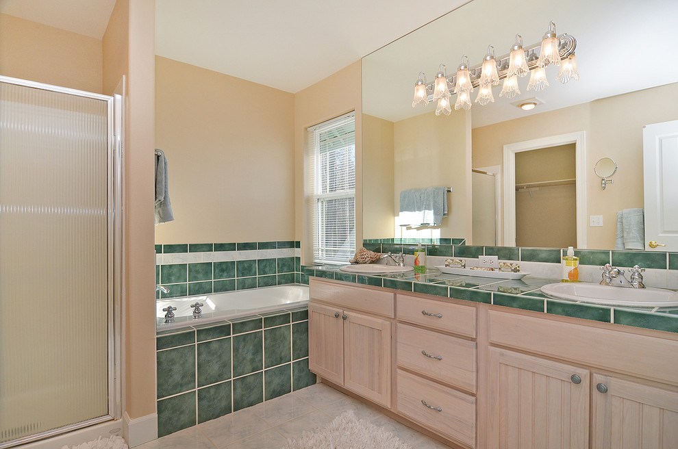 Large country master bathroom in Seattle with a drop-in sink, beaded inset cabinets, light wood cabinets, tile benchtops, a freestanding tub, an alcove shower, a two-piece toilet, green tile, porcelain tile, beige walls and ceramic floors.