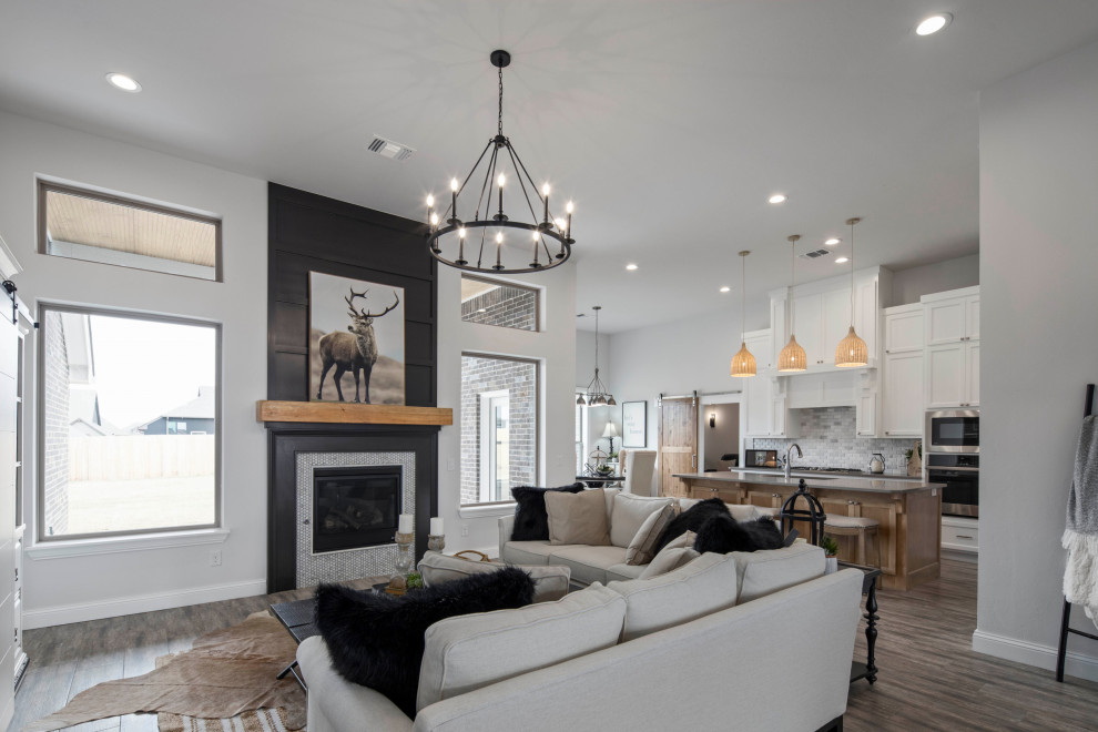 Offenes Landhausstil Wohnzimmer mit grauer Wandfarbe, Keramikboden, Kamin, Kaminumrandung aus Holz und braunem Boden in Oklahoma City