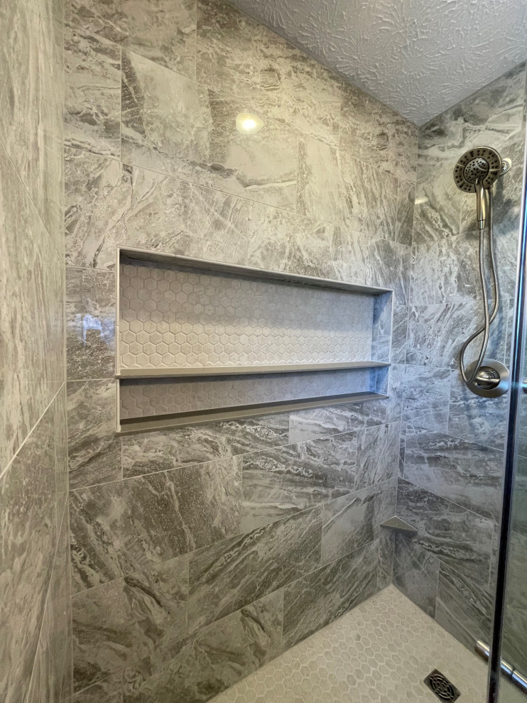 This is an example of a mid-sized modern master bathroom in Other with shaker cabinets, grey cabinets, an alcove shower, a two-piece toilet, gray tile, porcelain tile, white walls, vinyl floors, an integrated sink, marble benchtops, grey floor, a sliding shower screen, white benchtops, a niche, a double vanity and a built-in vanity.