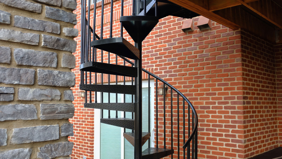 Mittelgroße Urige Treppe mit Metall-Setzstufen, Stahlgeländer und Ziegelwänden in Denver
