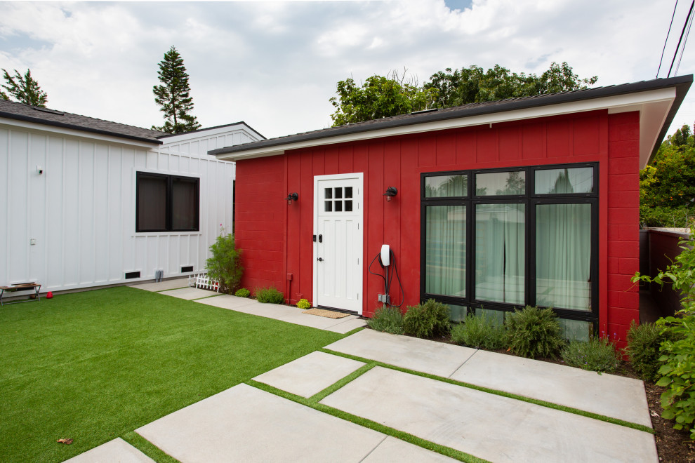 Photo of a medium sized and white farmhouse bungalow detached house in Los Angeles with concrete fibreboard cladding, a pitched roof, a mixed material roof, a black roof and board and batten cladding.