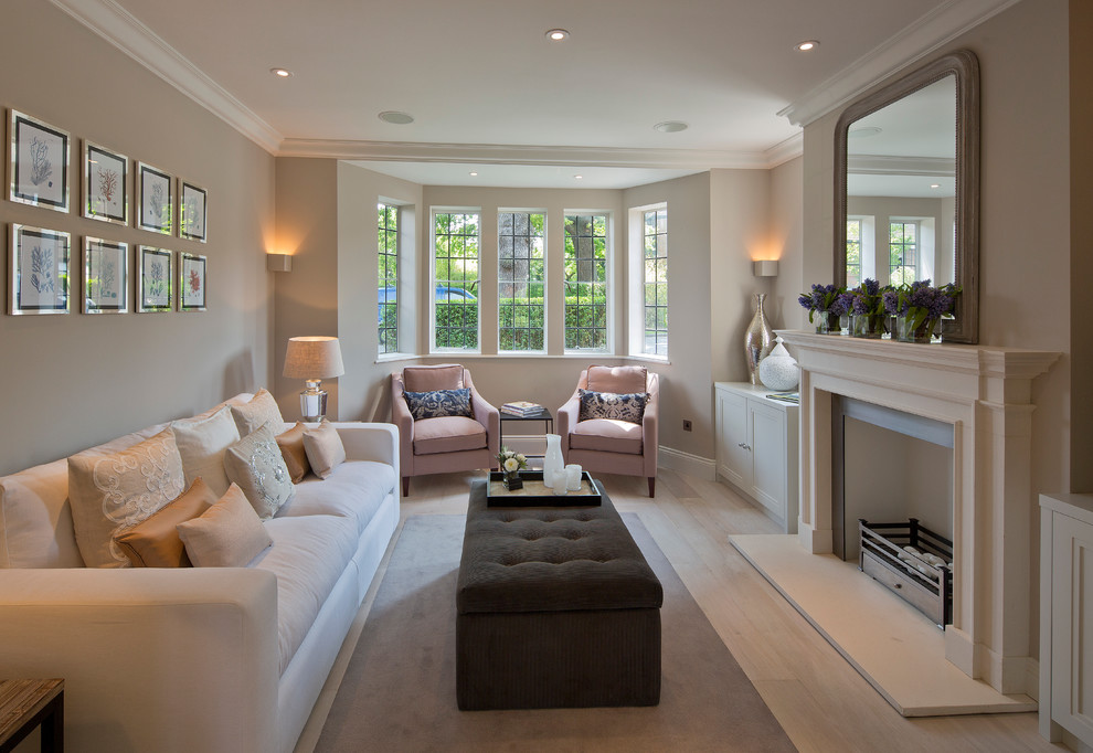 Transitional enclosed living room in London with beige walls and a standard fireplace.