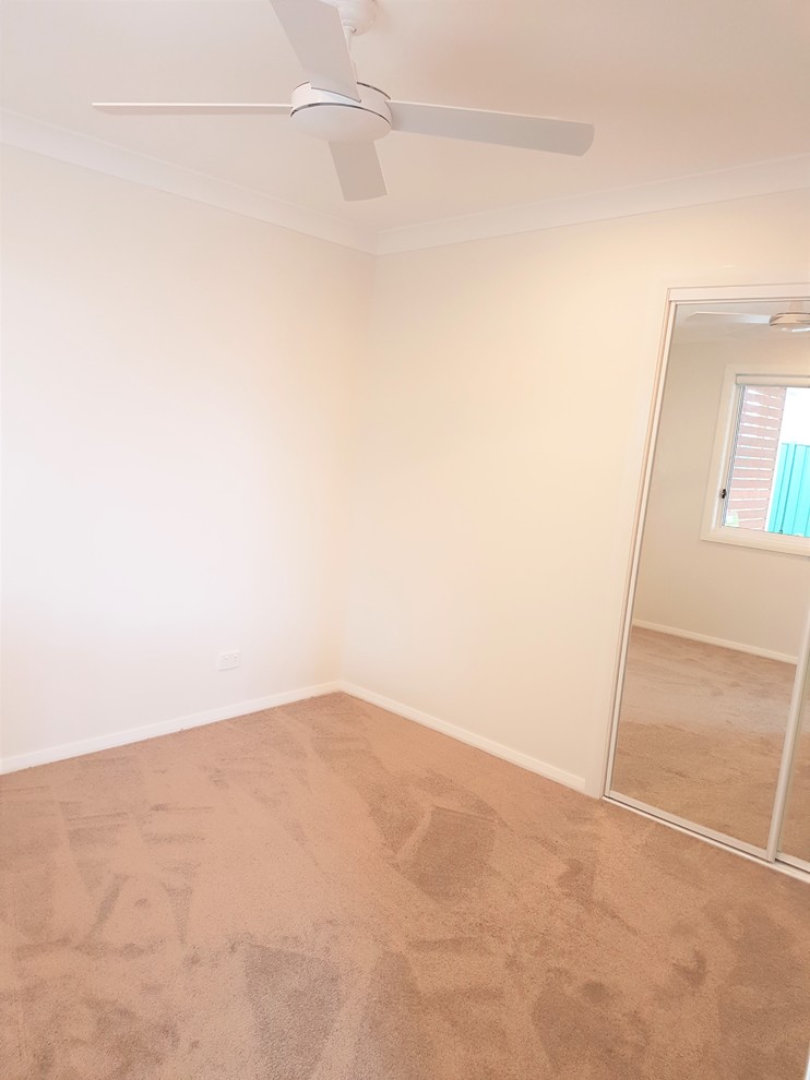 Small modern guest bedroom in Sydney with white walls, carpet and no fireplace.
