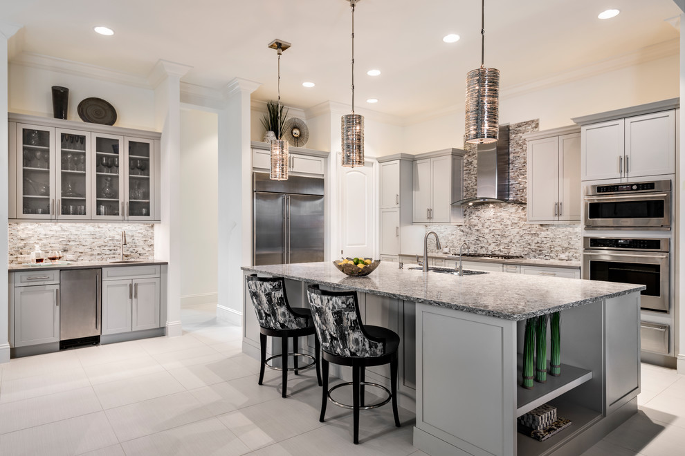 Design ideas for a transitional kitchen in Miami with an undermount sink, shaker cabinets, grey cabinets, multi-coloured splashback, mosaic tile splashback, stainless steel appliances, with island, grey floor and multi-coloured benchtop.