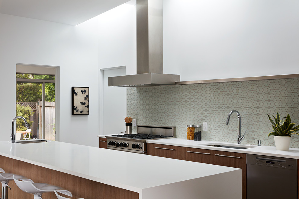 Inspiration for a mid-sized midcentury galley eat-in kitchen in San Francisco with an undermount sink, flat-panel cabinets, dark wood cabinets, green splashback, stainless steel appliances, with island, porcelain floors and brown floor.