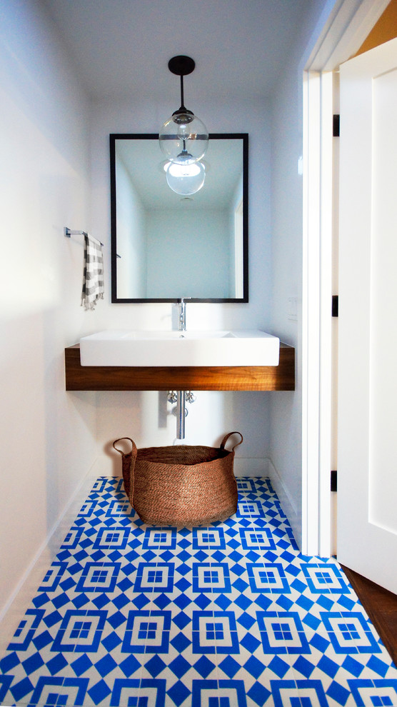 Photo of a small contemporary powder room in Austin with white walls, an integrated sink, open cabinets, medium wood cabinets, ceramic floors, wood benchtops, multi-coloured floor and brown benchtops.