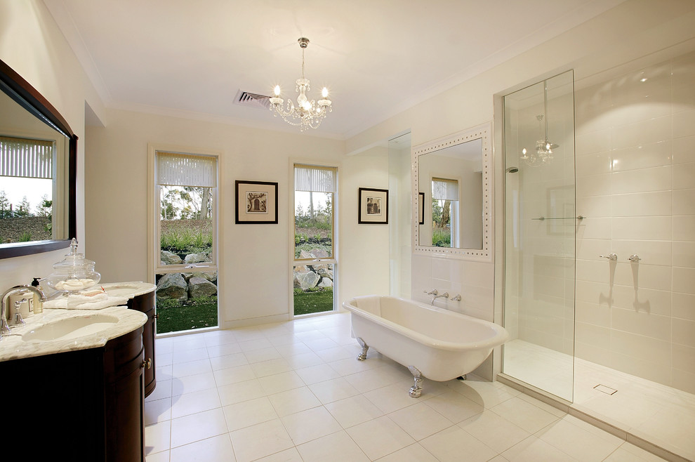 This is an example of a transitional master bathroom in Other with recessed-panel cabinets, dark wood cabinets, a claw-foot tub, an alcove shower, white tile, white walls, an undermount sink, white floor, an open shower and white benchtops.