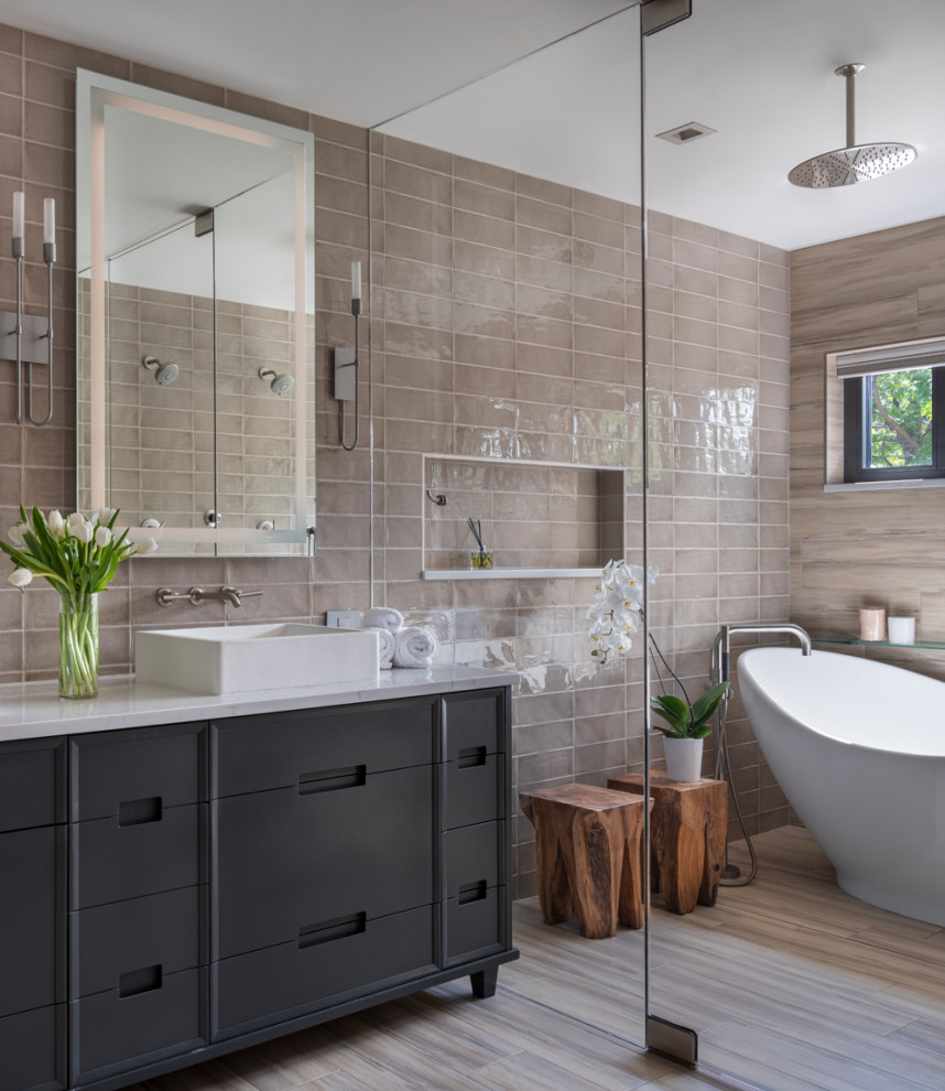 Inspiration for a mid-sized arts and crafts master wet room bathroom in Denver with furniture-like cabinets, grey cabinets, a freestanding tub, a one-piece toilet, beige tile, porcelain tile, porcelain floors, a vessel sink, engineered quartz benchtops, beige floor, a hinged shower door and white benchtops.