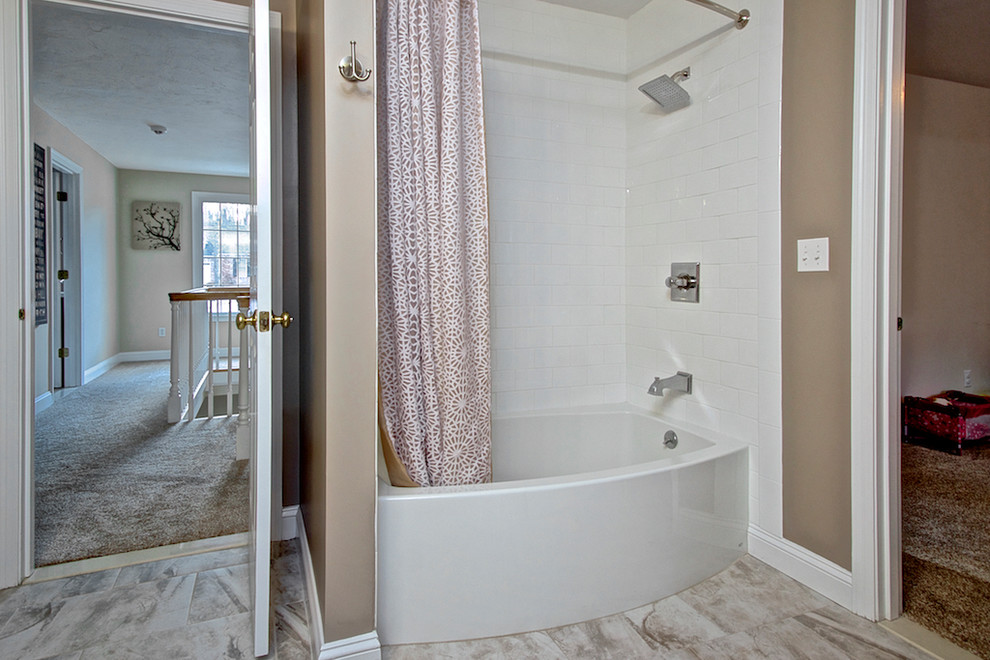 Large transitional kids bathroom in Boston with shaker cabinets, beige cabinets, an alcove tub, a shower/bathtub combo, a two-piece toilet, white tile, subway tile, beige walls, porcelain floors, a console sink and engineered quartz benchtops.