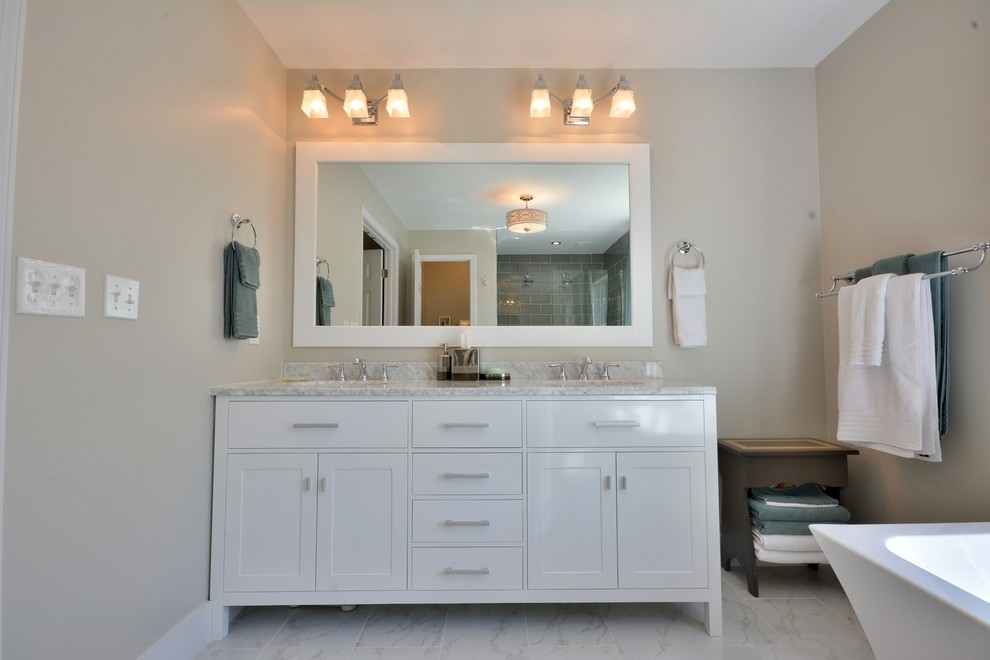 Photo of a large contemporary master bathroom in Atlanta with an undermount sink, shaker cabinets, white cabinets, marble benchtops, a freestanding tub, an open shower, white tile, stone tile, grey walls and marble floors.