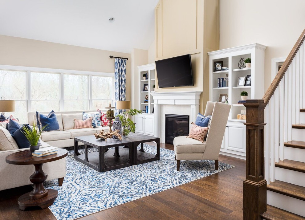 This is an example of a traditional formal open concept living room in Louisville with beige walls, medium hardwood floors and a standard fireplace.