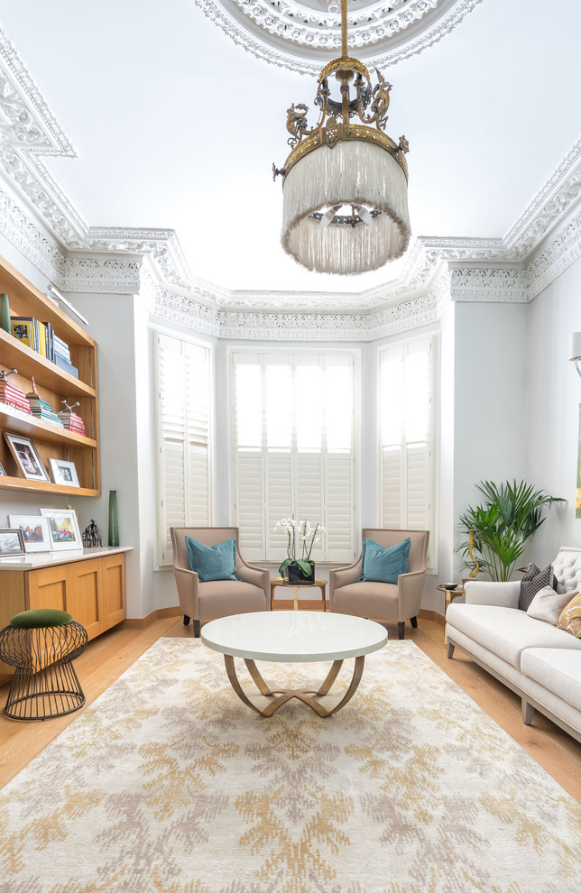 Design ideas for a mid-sized transitional formal enclosed living room in London with white walls, light hardwood floors and no fireplace.