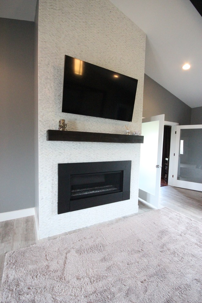 Large minimalist master ceramic tile home design photo with gray walls, a standard fireplace and a tile fireplace