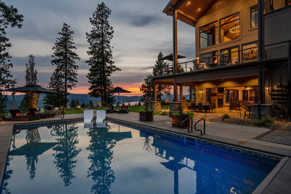 Esempio di una grande piscina monocorsia american style rettangolare dietro casa con paesaggistica bordo piscina e pavimentazioni in pietra naturale