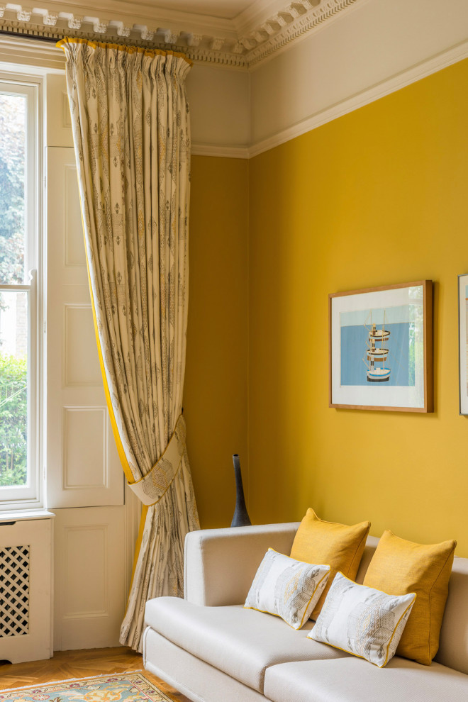 ロンドンにある高級な広いトランジショナルスタイルのおしゃれな独立型リビング (黄色い壁、無垢フローリング、茶色い床) の写真