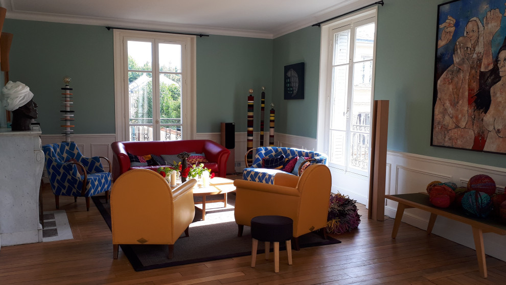 Großes, Offenes Modernes Wohnzimmer mit blauer Wandfarbe, hellem Holzboden, Kamin und vertäfelten Wänden in Paris