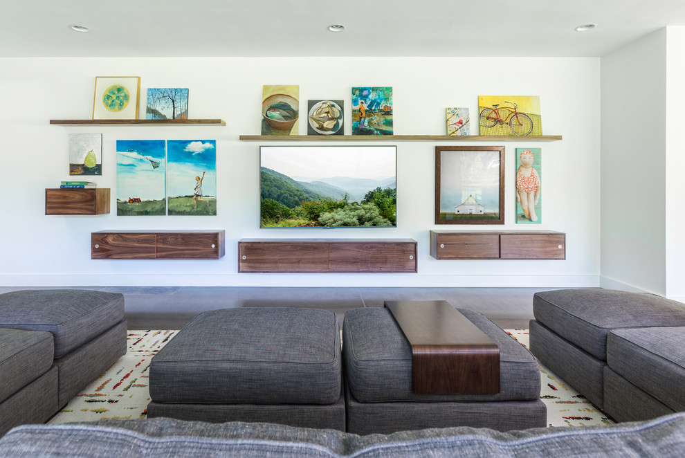 This is an example of a contemporary family room in Charleston with white walls and a wall-mounted tv.