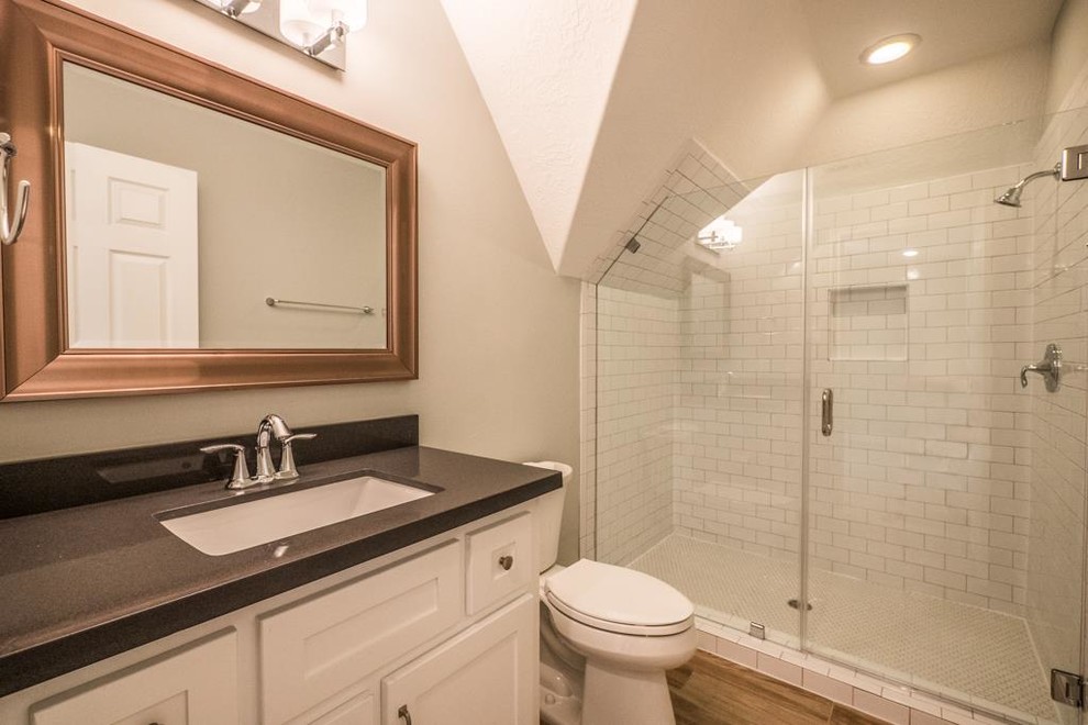 Photo of a mid-sized transitional 3/4 bathroom in Houston with an undermount sink, shaker cabinets, white cabinets, quartzite benchtops, a shower/bathtub combo, a two-piece toilet, beige tile, porcelain tile, green walls and porcelain floors.