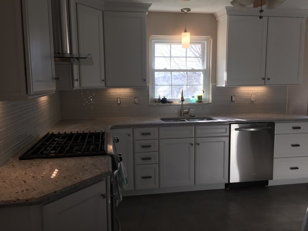 Inspiration for a mid-sized timeless u-shaped eat-in kitchen remodel with a double-bowl sink, recessed-panel cabinets, white cabinets, granite countertops, gray backsplash, glass tile backsplash and stainless steel appliances