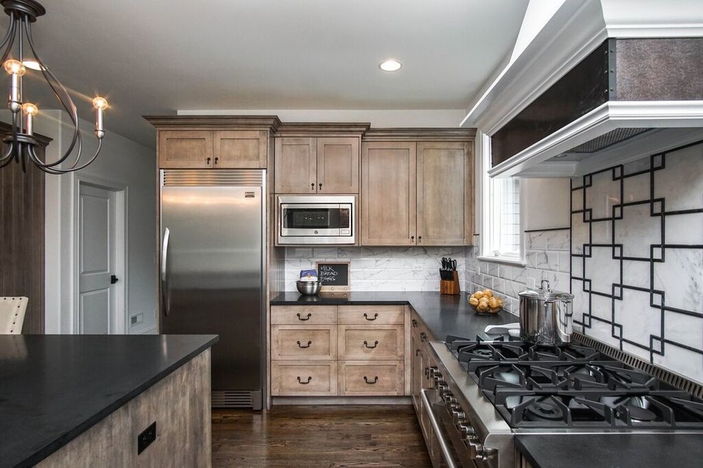 Inspiration for a transitional u-shaped dark wood floor and black floor eat-in kitchen remodel in Chicago with an undermount sink, shaker cabinets, granite countertops, white backsplash, ceramic backsplash, stainless steel appliances, an island and black countertops
