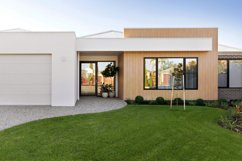 Large contemporary one-storey brick white house exterior in Other with a hip roof, a metal roof and a white roof.