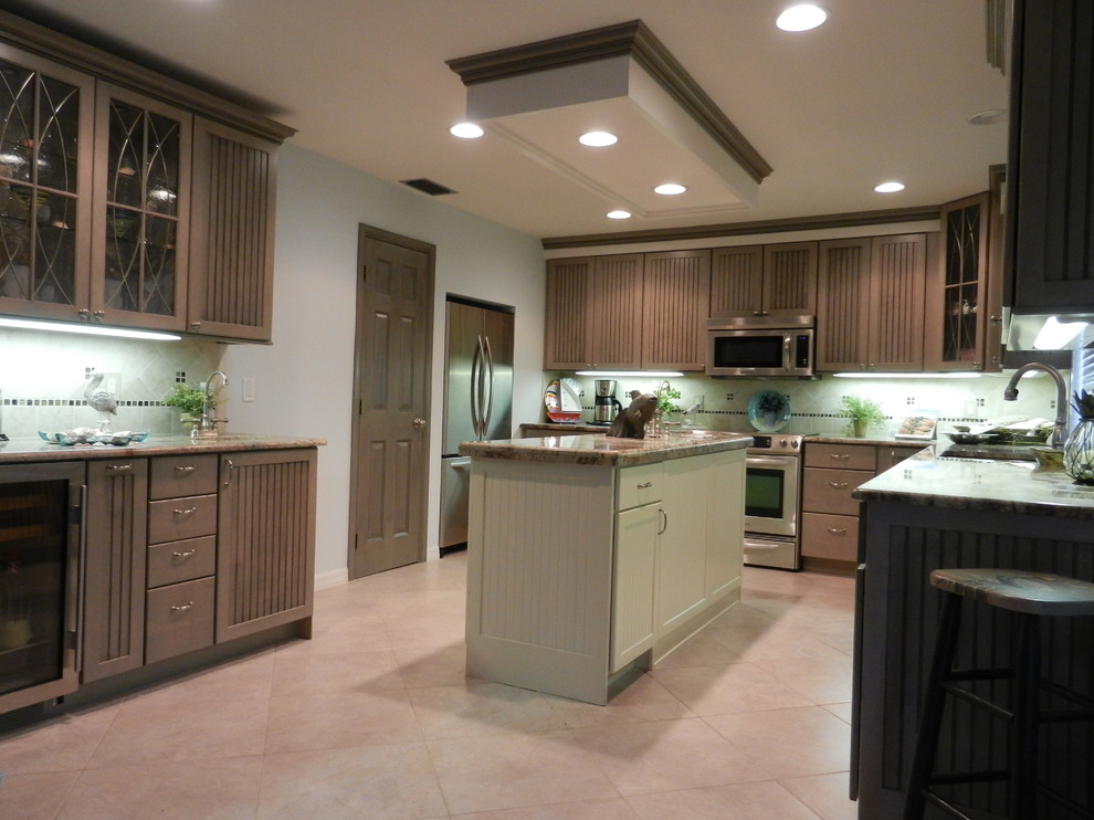 Large tropical u-shaped open plan kitchen in Miami with a double-bowl sink, beaded inset cabinets, grey cabinets, granite benchtops, beige splashback, porcelain splashback, stainless steel appliances, porcelain floors and with island.