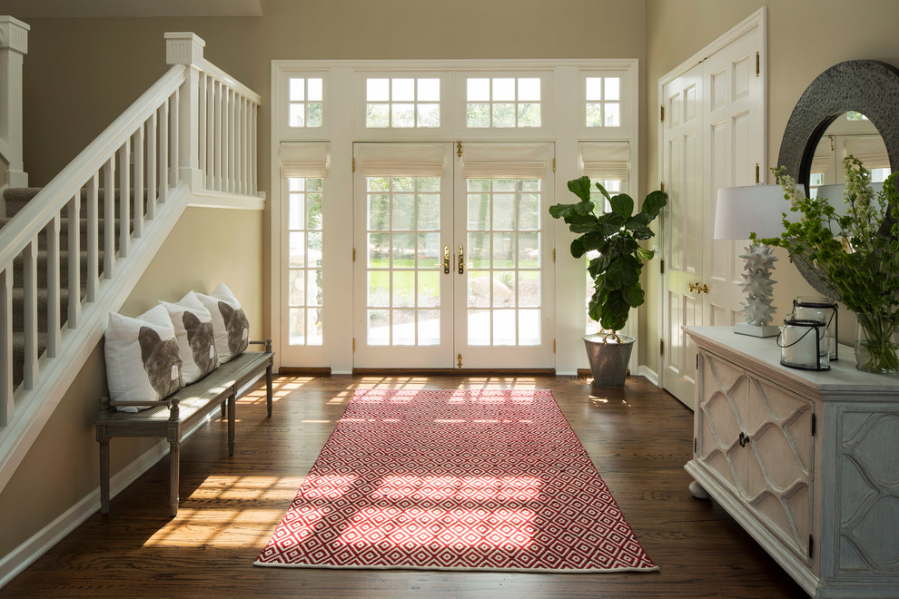 Elegant dark wood floor foyer photo in Minneapolis with beige walls and a glass front door