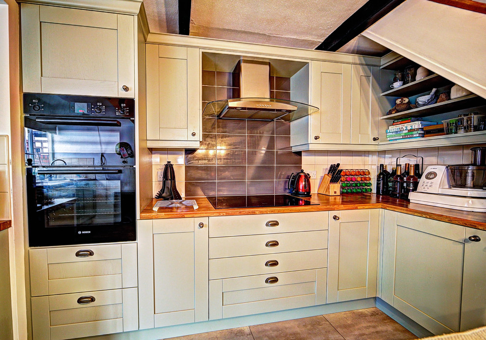 Inspiration for a large traditional eat-in kitchen in Manchester with shaker cabinets, green cabinets, laminate benchtops, grey splashback, ceramic splashback, black appliances, vinyl floors and no island.