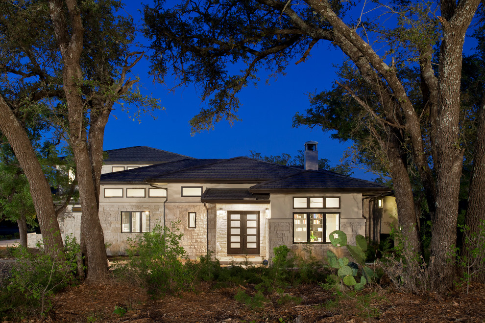Contemporary two-storey beige exterior in Austin with stone veneer and a hip roof.