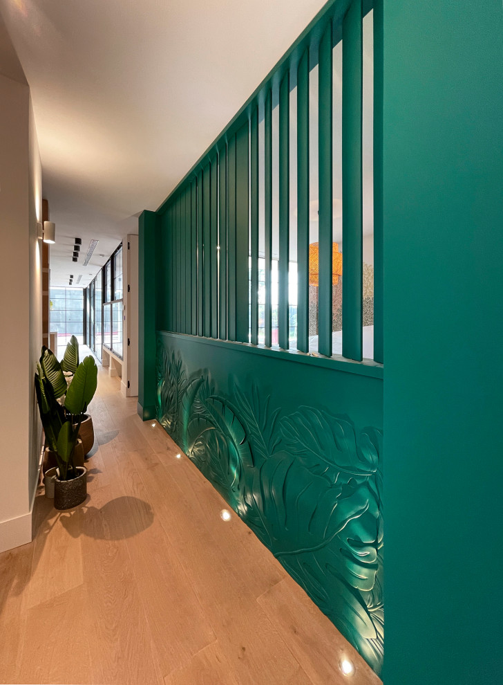 На фото: коридор среднего размера: освещение в морском стиле с зелеными стенами, паркетным полом среднего тона, коричневым полом и панелями на части стены с