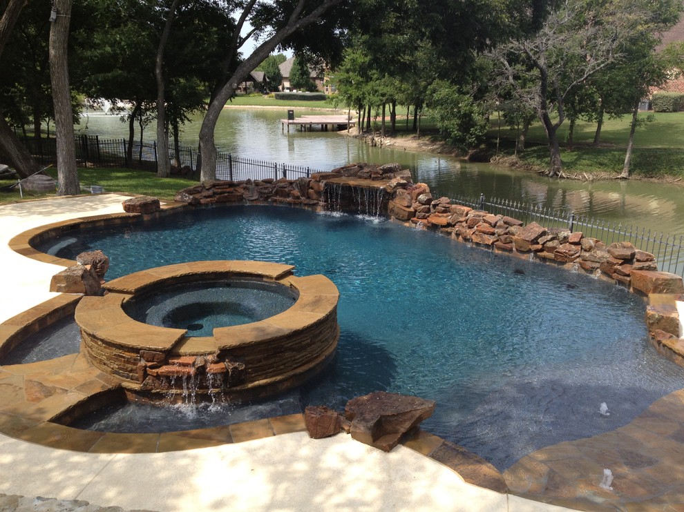 Mid-sized traditional backyard custom-shaped lap pool in Dallas with a hot tub.
