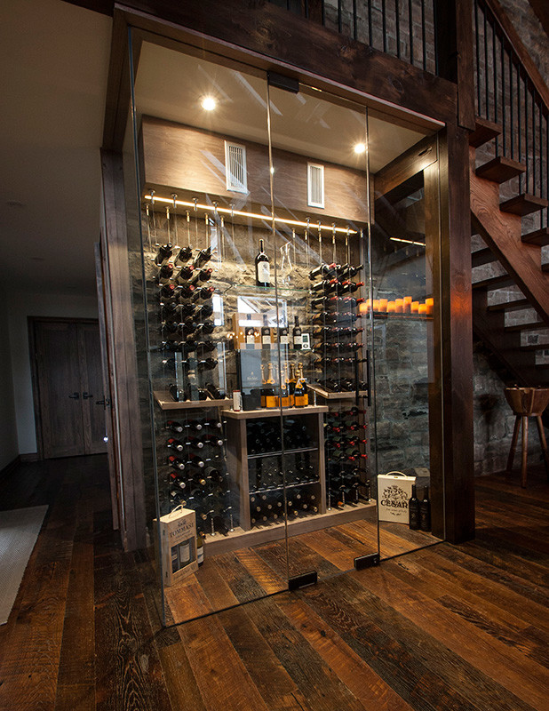 This is an example of a mid-sized contemporary wine cellar in Orange County with dark hardwood floors and storage racks.