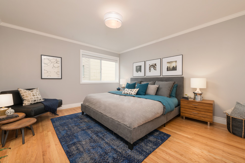 This is an example of a contemporary master bedroom in San Francisco with grey walls and light hardwood floors.