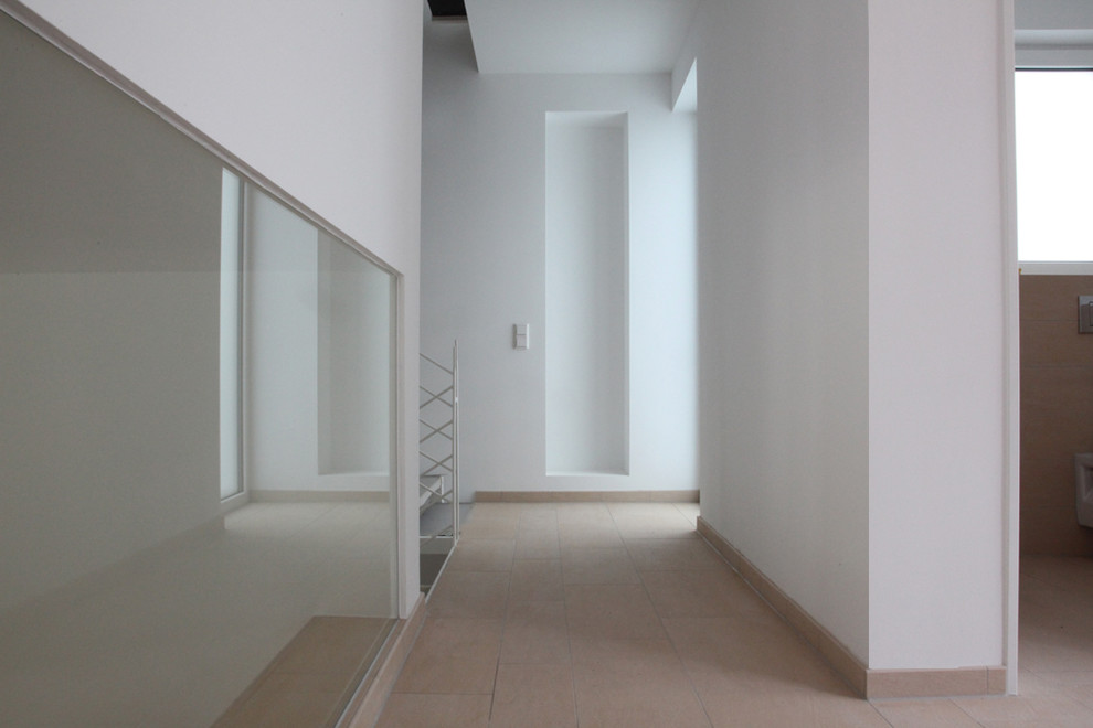 Moderner Flur mit weißer Wandfarbe und beigem Boden in München