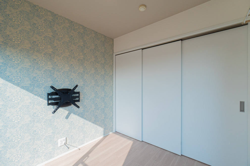 Modelo de sala de estar escandinava con paredes multicolor, suelo de contrachapado, televisor colgado en la pared, suelo beige, papel pintado y papel pintado