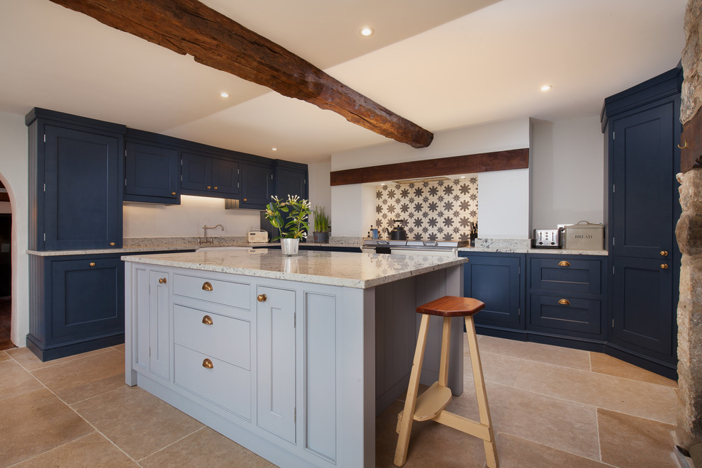 Mid-sized country l-shaped kitchen in Cornwall with a farmhouse sink, recessed-panel cabinets, granite benchtops, ceramic splashback, with island, beige floor, grey benchtop, blue cabinets and beige splashback.