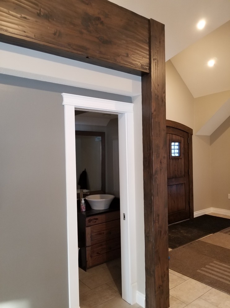 Example of a mountain style ceramic tile and beige floor front door design with beige walls and a dark wood front door