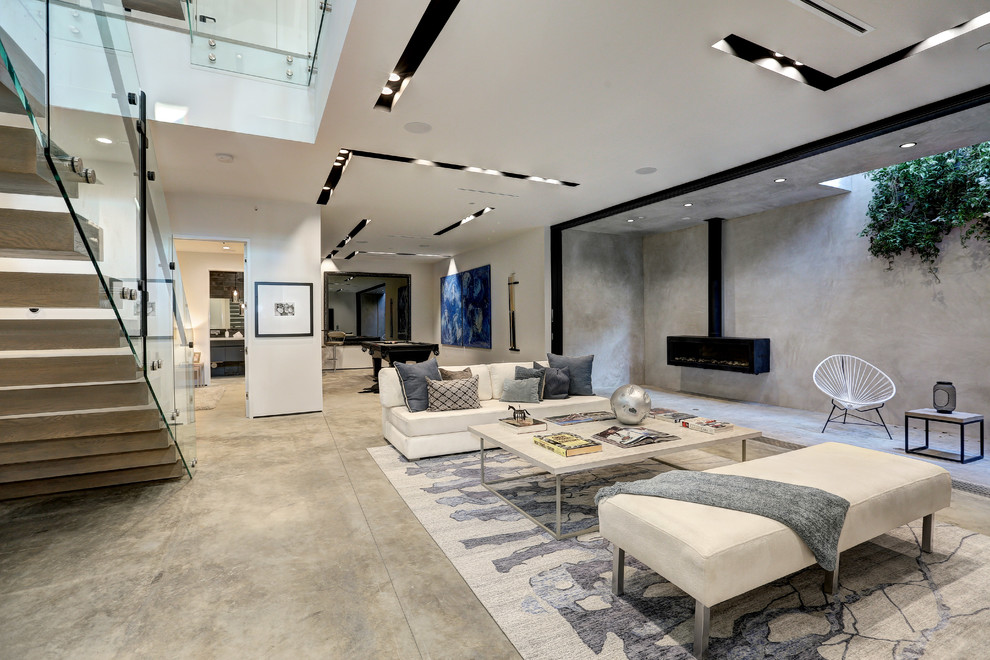 Design ideas for a contemporary open concept family room in Los Angeles with concrete floors, a hanging fireplace and grey floor.