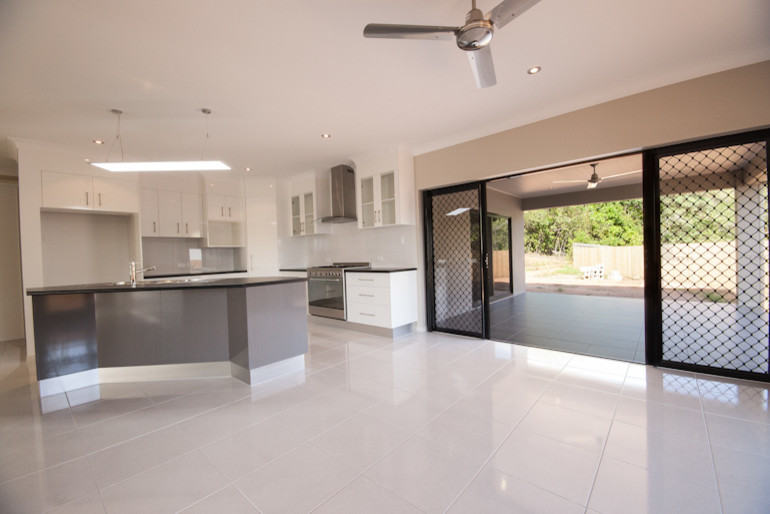 Design ideas for a large contemporary l-shaped eat-in kitchen in Cairns with a double-bowl sink, white cabinets, laminate benchtops, white splashback, ceramic splashback, stainless steel appliances, ceramic floors and with island.