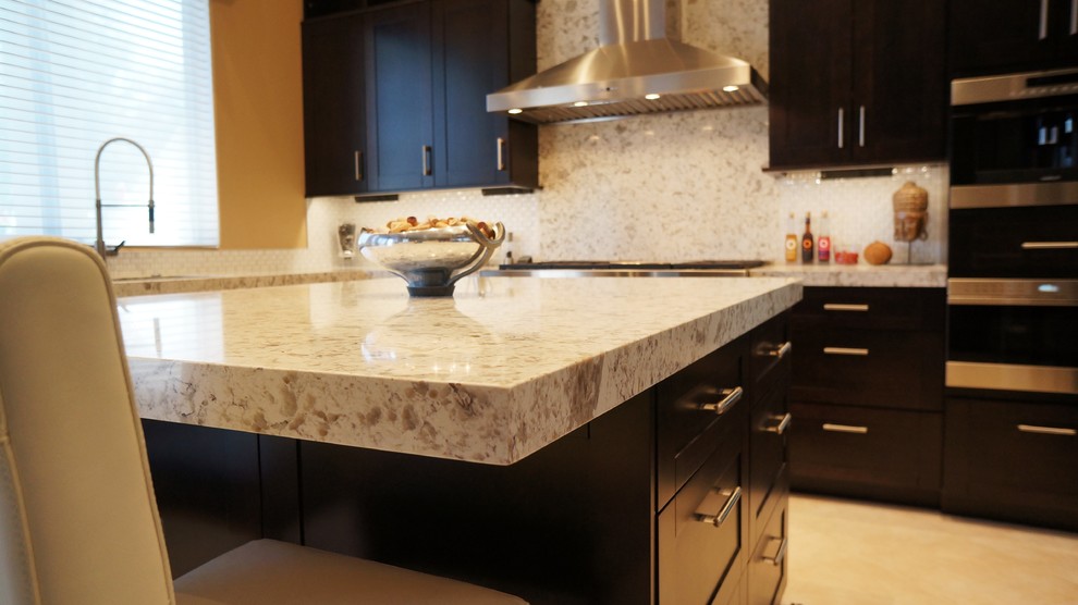 Transitional l-shaped porcelain tile and beige floor kitchen photo in Phoenix with an undermount sink, recessed-panel cabinets, dark wood cabinets, quartz countertops, white backsplash, ceramic backsplash, stainless steel appliances and an island