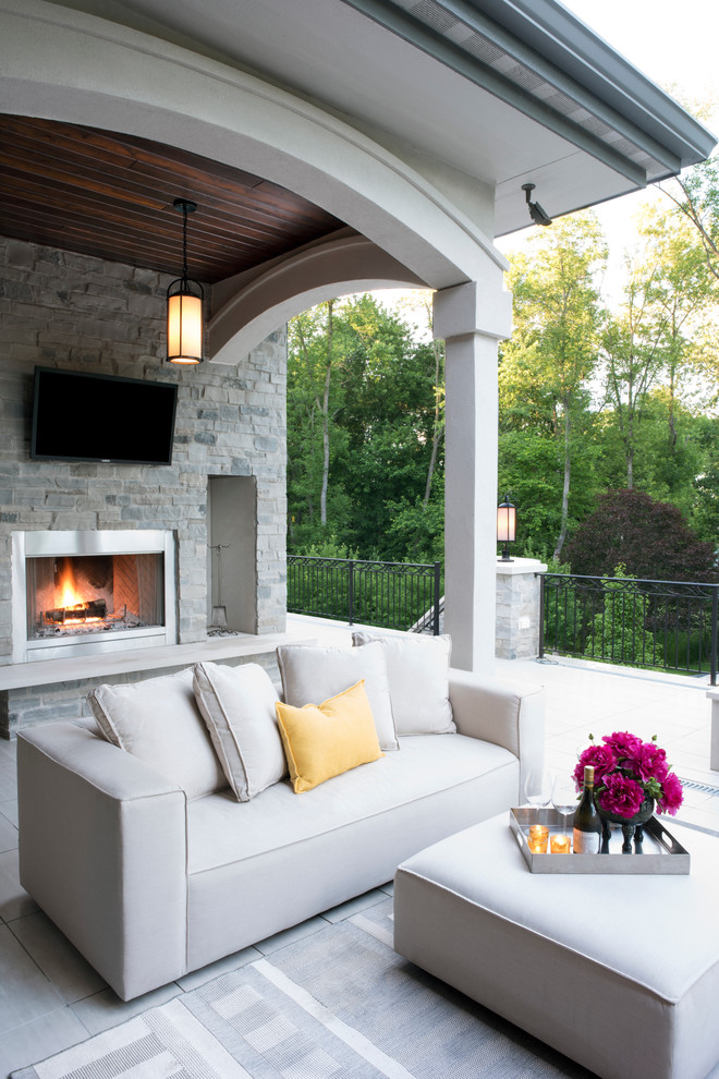 Design ideas for a large mediterranean backyard deck in Milwaukee with with fireplace and a roof extension.
