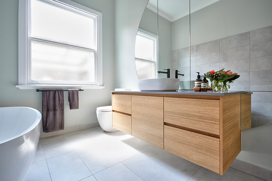 Inspiration for a large contemporary 3/4 bathroom in Melbourne with flat-panel cabinets, brown cabinets, a freestanding tub, an open shower, a wall-mount toilet, porcelain tile, porcelain floors, a vessel sink and solid surface benchtops.