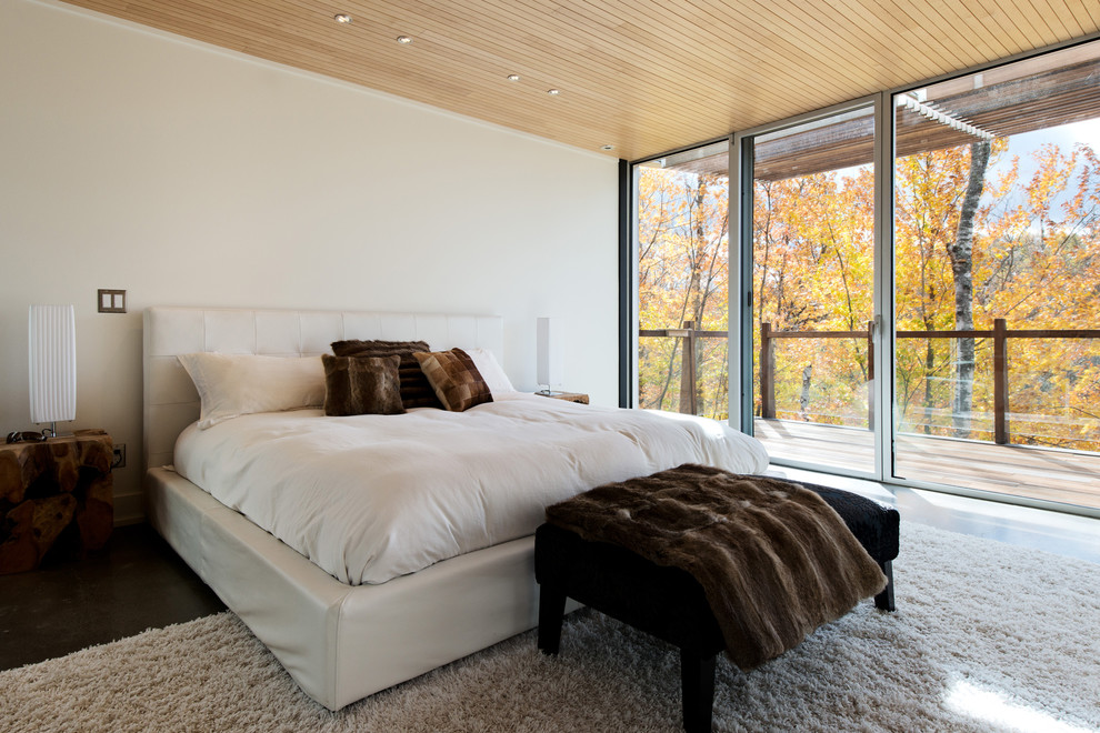 This is an example of a contemporary bedroom in Montreal with white walls and dark hardwood floors.
