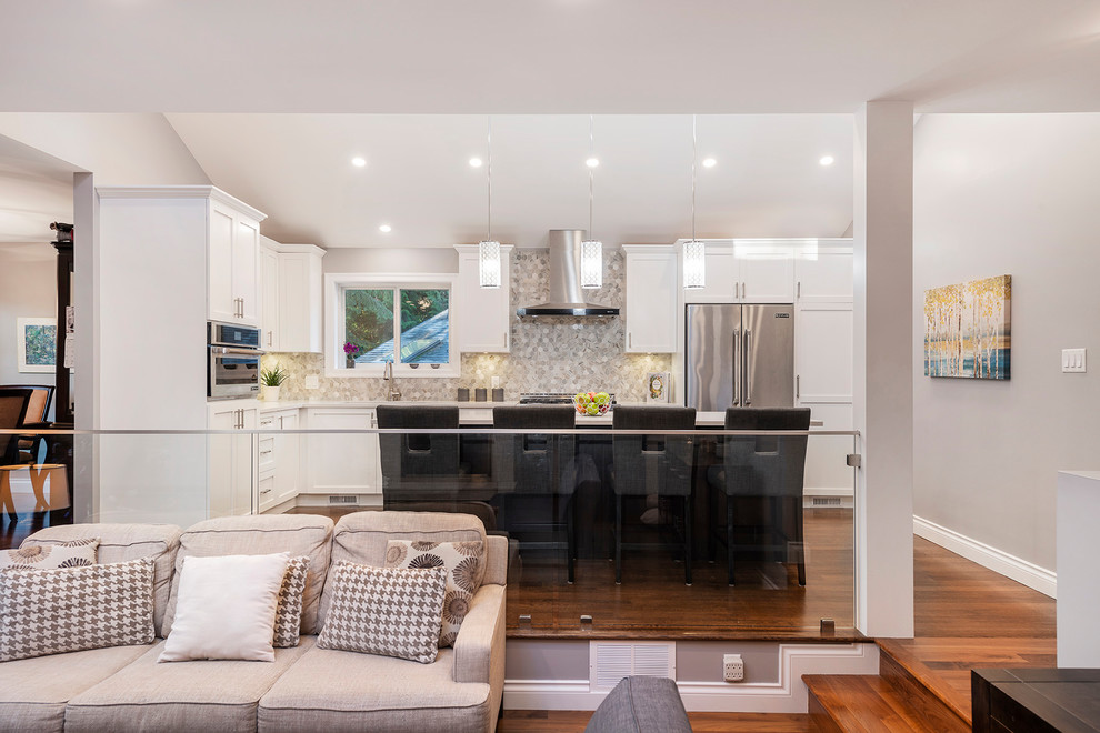 Inspiration for a large transitional l-shaped medium tone wood floor and brown floor eat-in kitchen remodel in Vancouver with an undermount sink, shaker cabinets, white cabinets, quartzite countertops, multicolored backsplash, marble backsplash, stainless steel appliances, an island and white countertops