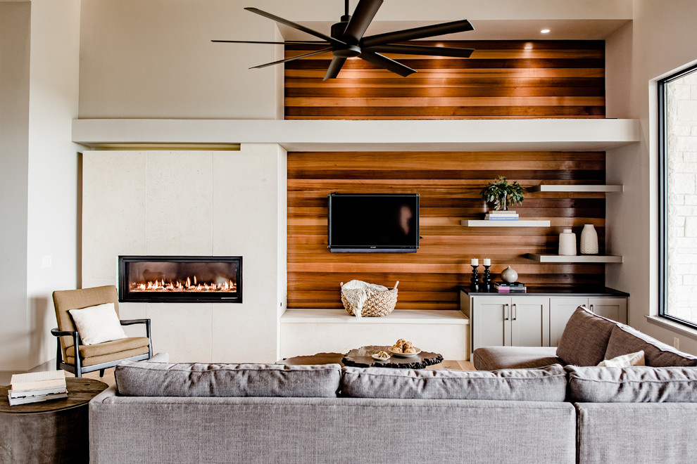 Inspiration for a large contemporary open concept family room in Austin with a wall-mounted tv, white walls, a ribbon fireplace and a stone fireplace surround.