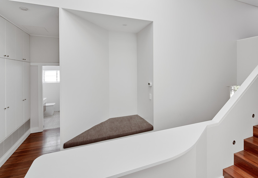 This is an example of a mid-sized contemporary hallway in Sydney with white walls and dark hardwood floors.