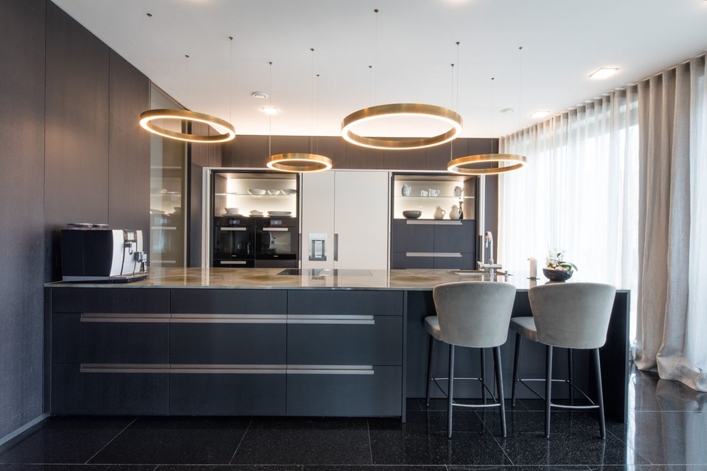 Photo of a large contemporary kitchen in Other with an undermount sink, flat-panel cabinets, black cabinets, panelled appliances, a peninsula, black floor and grey benchtop.