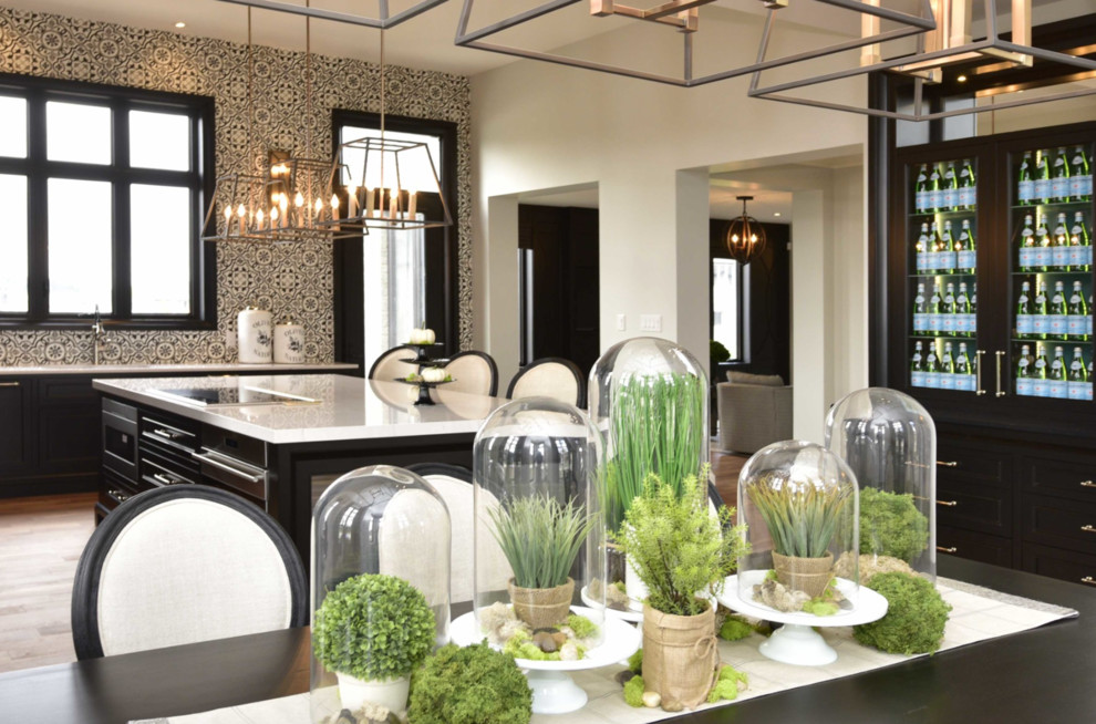 Large transitional l-shaped medium tone wood floor and brown floor eat-in kitchen photo with an undermount sink, recessed-panel cabinets, black cabinets, marble countertops, multicolored backsplash, cement tile backsplash, paneled appliances and an island